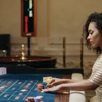 Stylish woman in a casino setting, playing roulette with stacks of chips. — How To Prevent MISTAKESINSlots