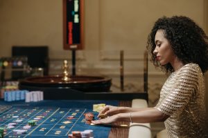 Stylish woman in a casino setting, playing roulette with stacks of chips. — How To Prevent MISTAKESINSlots