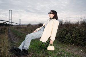 A stylish woman in sunglasses relaxes on a chair by a bridge in nature. — A Comprehensive Overview of Gaming Communit