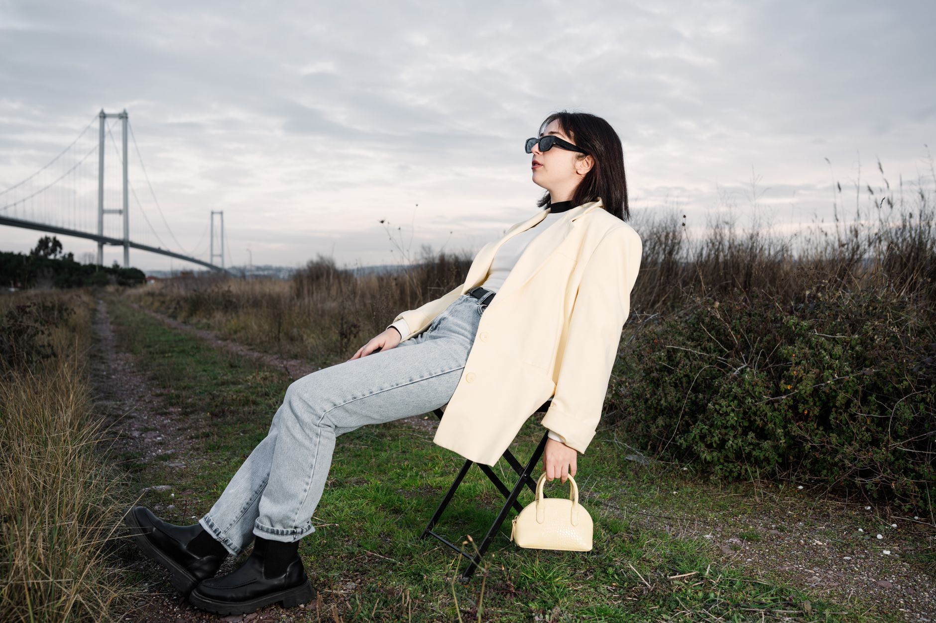 A stylish woman in sunglasses relaxes on a chair by a bridge in nature. — A Comprehensive Overview of Gaming Communit