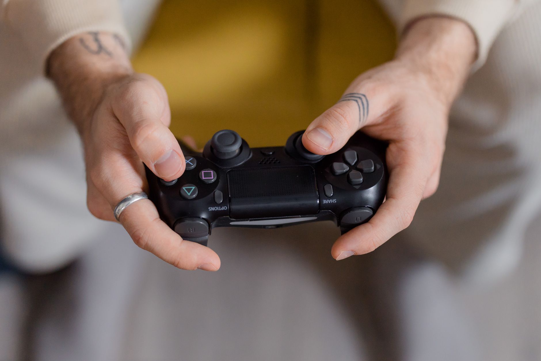 A gamer holding a black game controller, focusing on gaming and entertainment. — All Your Favorite Games Now in One P