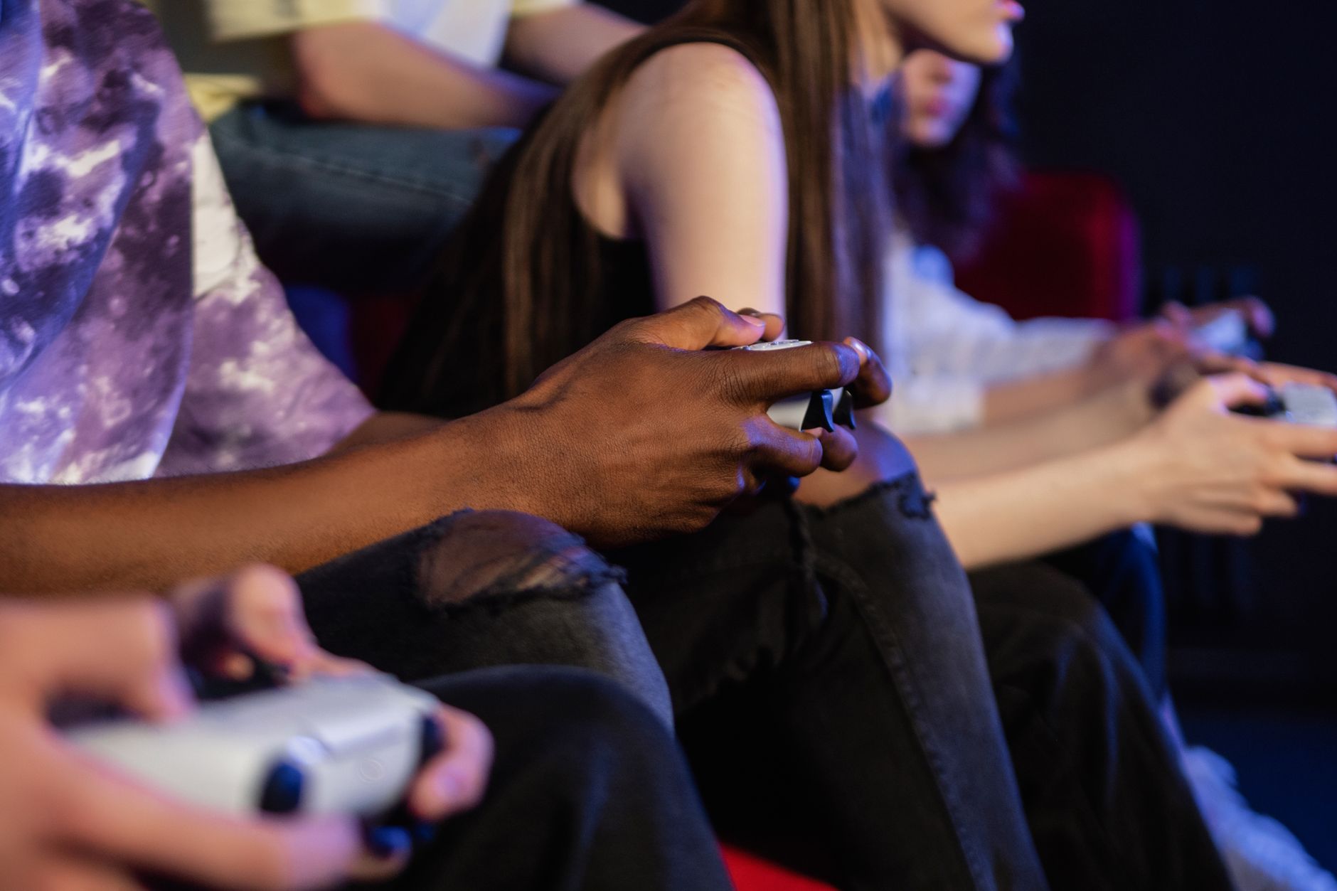 Teens playing video games with controllers, focused and engaged. — Hedging Your Bets: A Risk Management Strategy for