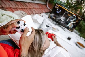 A couple playing video games outdoors, focusing on the controllers and screen. — The Best Online Casinos To Play Now - Get A