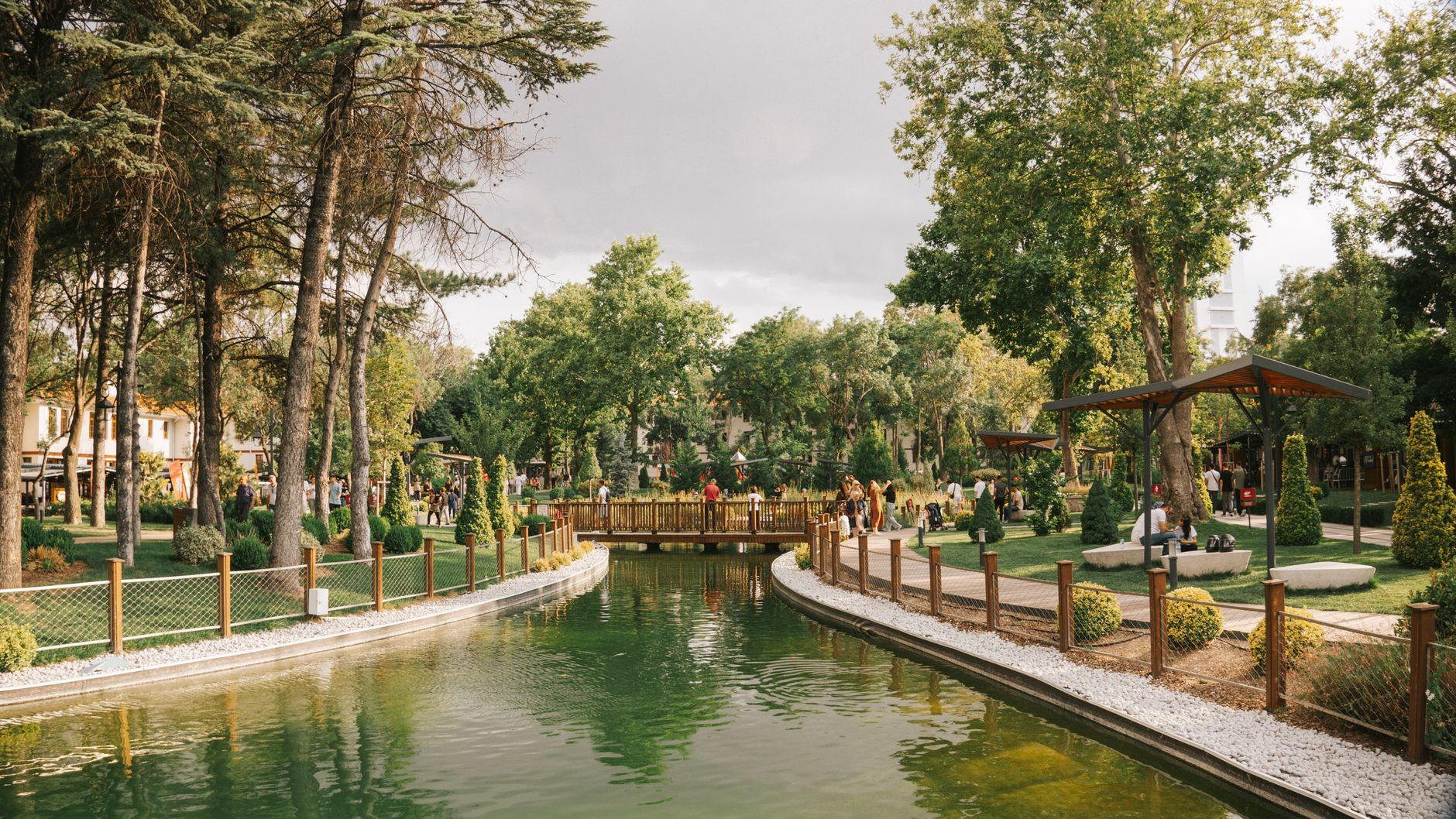 Peaceful park scene featuring a serene pond, a wooden bridge, and lush greenery. — The Epitome of Entertainment: Experience t