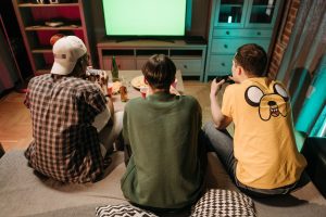 Three young men enjoying a home gaming session together, playing video games in a cozy indoors setting. — What Are The Strate
